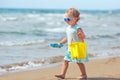 Child playing on tropical beach. Little girl digging sand at sea shore. Kids play with sand toys. Travel with young children Royalty Free Stock Photo