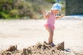 Child playing on tropical beach. Little girl digging sand at sea shore. Travel with young children Royalty Free Stock Photo