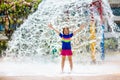 Child playing under tip bucket in water park