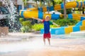 Child playing under tip bucket in water park