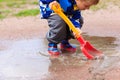 Child playing in water puddle, kids spring activities Royalty Free Stock Photo