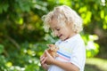 Child playing with white rabbit. Little boy feeding and petting white bunny. Easter celebration. Egg hunt with kid and pet animal Royalty Free Stock Photo