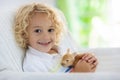 Child playing with white rabbit. Little boy feeding and petting white bunny. Easter celebration. Egg hunt with kid and pet animal Royalty Free Stock Photo