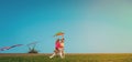 Child playing with the wind near a wind turbine. Children running on the green field. Renewable energies and sustainable Royalty Free Stock Photo