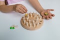 Child playing wooden board game with hands and colored dice on white table Royalty Free Stock Photo