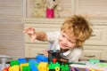 Child in playroom. Kids face, little boy playing with colorful blocks, portrait.