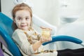 Child plays with artificial human jaw in dentist chair