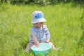 Child plays with a basin of water on the grass. Funny Baby Boy Playing Outside with Water and Bubbles. A cute baby boy is making a Royalty Free Stock Photo