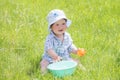 Child plays with a basin of water on the grass. Funny Baby Boy Playing Outside with Water and Bubbles. A cute baby boy is making a Royalty Free Stock Photo