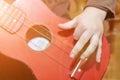 The child plays a children`s guitar. Hand on musical instrument