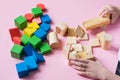 The child plays collects wooden colored cubes constructor. Education concept for special children learning. Royalty Free Stock Photo