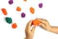 A child plays with colored modeling clay, plasticine on a white background