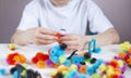 A child plays with colorful mosaic at the table. Quarantine of children at home Royalty Free Stock Photo