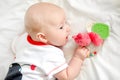 The child plays with an educational toy. The first toys of babies. Learning from diapers. Newborn learns to hold the