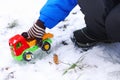 The child plays among the first snow with a red machine Royalty Free Stock Photo