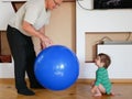 The child plays with the grandfather a ball. play a big blue ball at home. A boy is playing with his grandfather Royalty Free Stock Photo