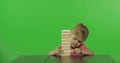 The child plays the jenga. Little girl pulls wooden blocks from a tower