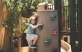 Child plays on a kids playground. Little boy climbing rock wall. Royalty Free Stock Photo