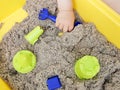 A child plays with kinetic sand: closeup of a child`s hand and sand Royalty Free Stock Photo