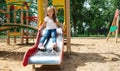 The child plays in the outdoor playground. Children play in the courtyard of a school or kindergarten. Healthy summer fun for kids Royalty Free Stock Photo