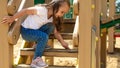 The child plays in the outdoor playground. Children play in the courtyard of a school or kindergarten. Healthy summer fun for kids Royalty Free Stock Photo