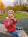 Child plays photographer outdoors. Girl imagines taking pictures on pink plastic toy phone Royalty Free Stock Photo