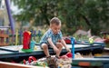 A child plays in the playground with toys in the sandbox. Toddler boy plays in the sand in the summer Royalty Free Stock Photo