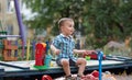 A child plays in the playground with toys in the sandbox. Toddler boy plays in the sand in the summer Royalty Free Stock Photo