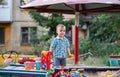 A child plays in the playground with toys in the sandbox. Toddler boy plays in the sand in the summer Royalty Free Stock Photo