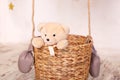 A child plays with a plush bear. Kids toys. Teddy sitting in the balloon basket, aerostat. Retro teddy bear. Toy teddy bear alone