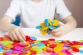 A child plays with a round colored mosaic. Game process close up. Hands close up Royalty Free Stock Photo