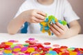 A child plays with a round colored mosaic. Game process close up. Hands close up. Quarantined home art Royalty Free Stock Photo