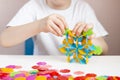 A child plays with a round colored mosaic. Game process close up. Hands close up. Quarantined home art. The development of fine Royalty Free Stock Photo