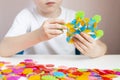 A child plays with a round colored mosaic. Game process close up. Hands close up. Quarantined home art. The development of fine Royalty Free Stock Photo