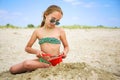 Child plays with sand on beach