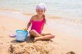 Child plays in the sand shovel and bucket on the sea shore Royalty Free Stock Photo