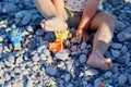 A child plays with toys and pebbles on the beach. The concept of recreation, play and the development of children& x27;s Royalty Free Stock Photo