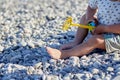 A child plays with toys and pebbles on the beach. The concept of recreation, play and the development of children& x27;s Royalty Free Stock Photo