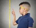 Child pointing at his height on measuring tape Royalty Free Stock Photo