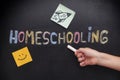 Child pointing at word Homeschooling on a blackboard