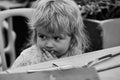 Child pondered. Baby boy in outdoor cafe