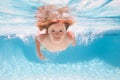 Child in pool in summer day. Young boy swim and dive underwater. Under water portrait in swim pool. Child boy diving Royalty Free Stock Photo