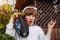 Child with portable speaker enjoying the music in park, outdoors. Kid listening music by wireless acoustic column at nature. Boy