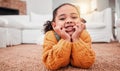 Child, portrait and girl kid lying on the floor in a home lounge or living room resting with a smile, happy and excited Royalty Free Stock Photo