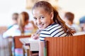 Child, portrait and school desk in classroom with notebook or lesson studying in academy or education, learn or Royalty Free Stock Photo