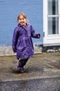 Child, portrait and splash in mud puddle in raincoat for winter fun, explore city or cold weather happy. Young girl