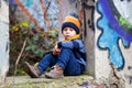 Child, posing in an old ruin building, sprayed with graffiti