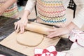 child potter rolls a brown clay with rolling pin on a special board on a wooden table to make a plate.Pottery workshop Royalty Free Stock Photo