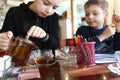 Child pouring tea in cafe