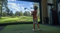 Child practices golf swing indoors with virtual golf simulator on sunny day Royalty Free Stock Photo